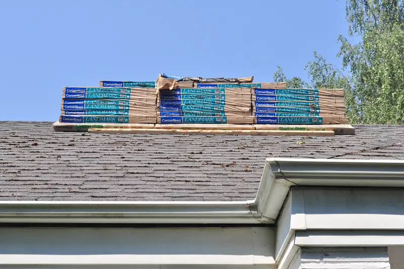 Bundles of new asphalt shingles staged on a roof